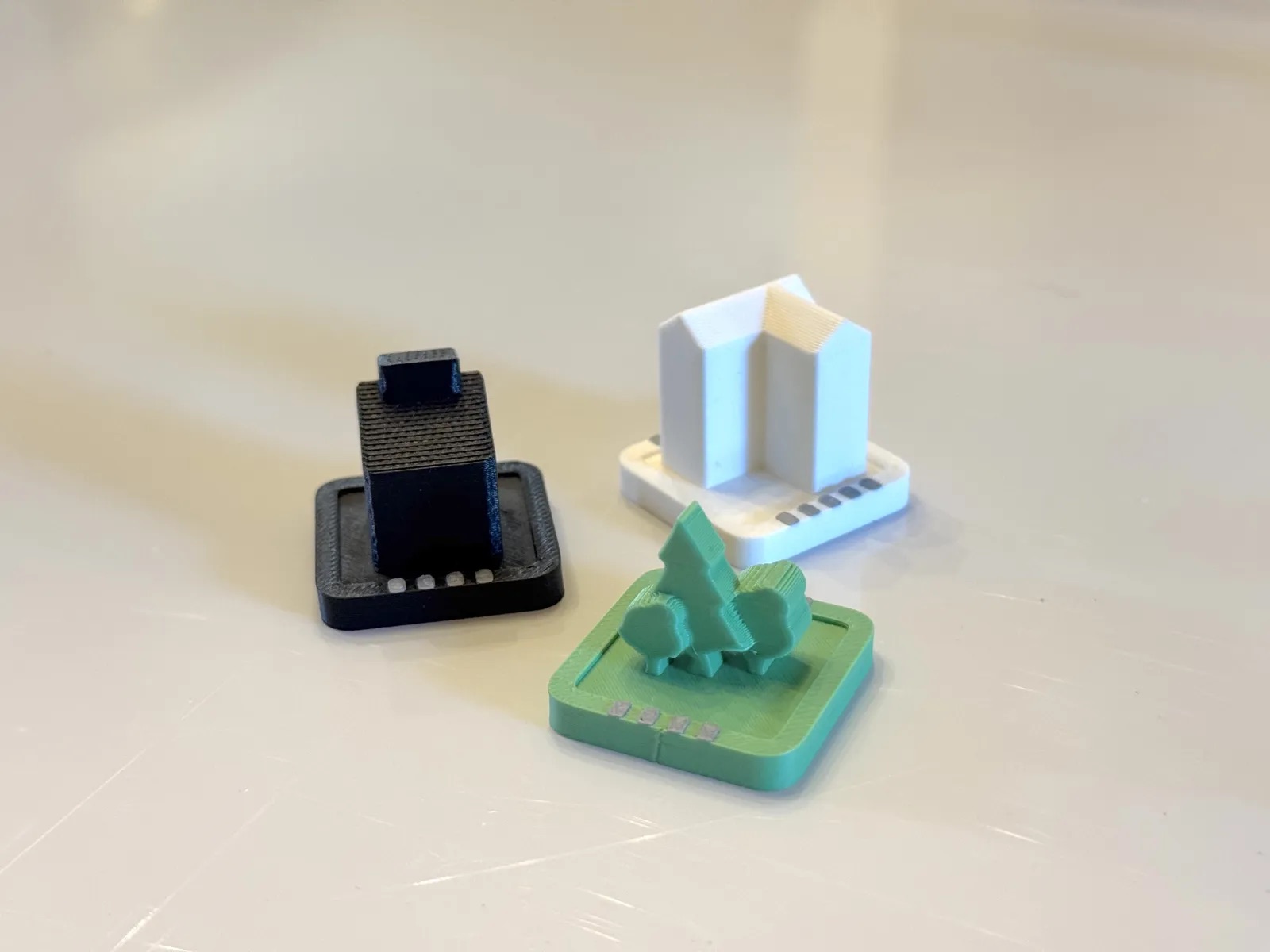 City Swap pieces: a black tower, a white building, and a green park